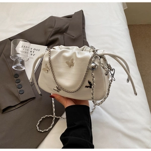Détail du sac nuage plissé blanc avec papillons argentés et bandoulière en chaîne