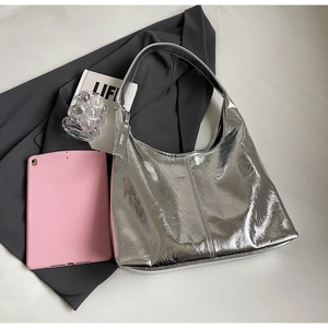 Close-up of metallic silver hobo bag with crinkle texture and stylish brand tag detail