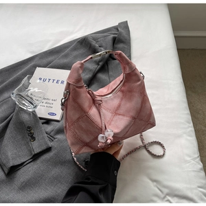 Close-up of pink quilted dumpling bag with silver hardware and chain strap detail