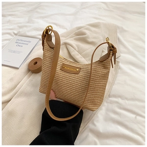 Détail du sac croissant tissé avec bandoulière en cuir marron et boucles dorées chic