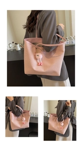 Détail du sac cabas rose tissé avec anses en cuir et un pendentif peluche mignon
