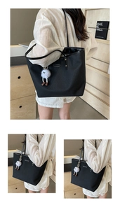 Détail du grand sac cabas noir tissé avec texture verticale et pendentif en peluche