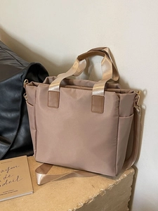 Khaki nylon tote bag with leather handles and adjustable strap for casual daily use