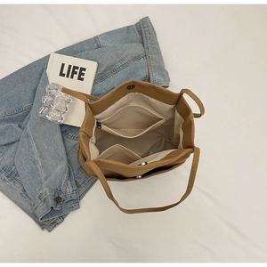Interior view of brown canvas tote bag showing zipper pocket and spacious layout