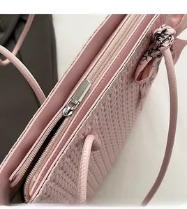 Detail of silver smooth zipper and woven texture on a pale pink tote bag with scarf decor