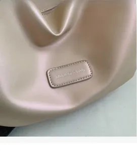 Macro shot of metallic faux leather texture with MULAIDI & BAG logo and zipper detail