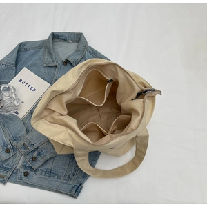 Top view of spacious interior with zipper pocket and dual open slots in beige nylon tote