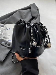 Chic black glossy leather bucket bag with silver chain strap and metal ball charm