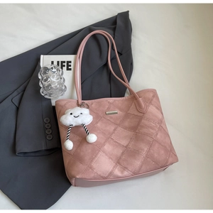 Detail of pink quilted tote bag with metallic logo and white cloud plush charm