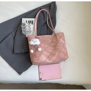 Detail of pink quilted tote bag with suede texture and cloud charm on a white background