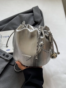 Chic silver metallic drawstring bucket bag with pleated texture and silver chain strap