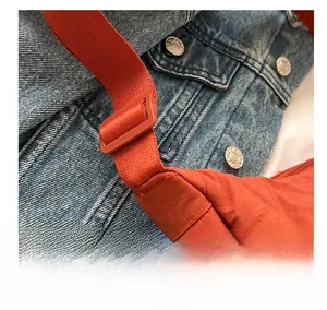 Detail of orange nylon dumpling bag showing high-quality stitching and adjustable strap