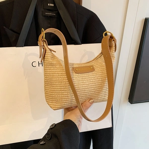 Sac bandoulière chic en paille tressée beige avec lanières en cuir marron et boucles