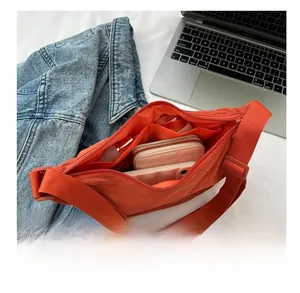 Detail view of large capacity orange crossbody bag with multiple inner compartments