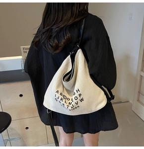 Detail of canvas tote bag showing large capacity and black letter print decoration