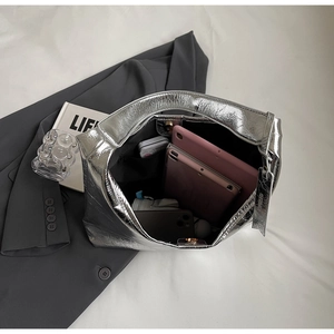 Interior view of large silver metallic tote bag showing spacious storage for a tablet and phone