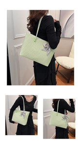 Detail of light green woven tote bag with a grey silk bow accessory for workwear