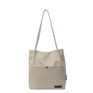 Minimalist off-white canvas tote bag with shoulder strap and metal snap button pocket