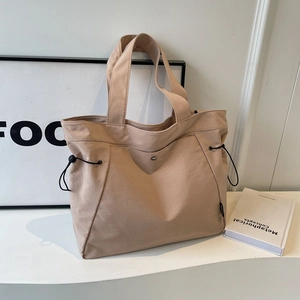 Minimalist large nylon tote bag in khaki with drawstring side and metal snap closure
