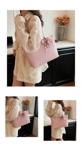Detail of pink woven tote bag with floral silk scarf accessory and slim shoulder straps
