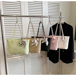 Detailed view of woven tote bags in five colors with decorative silk scarf handles