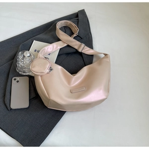 Pink hobo shoulder bag with round coin purse and adjustable strap on a minimalist background