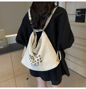 Detail of a minimalist cream canvas tote bag showing its unique triangular shape and print