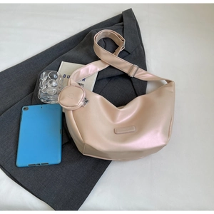 Detail view of pink crescent crossbody bag with round coin purse on a grey blazer
