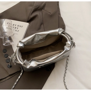 Détails intérieurs du sac seau argenté avec fermoir magnétique et bandoulière chaîne