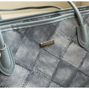 Close-up of blue denim checkerboard tote bag with MEIGEFEI metal logo and fine stitching