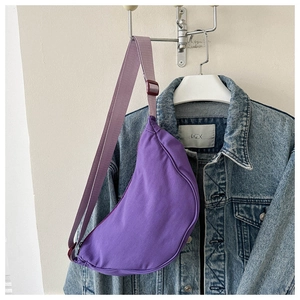 Detail view of purple canvas crescent bag featuring adjustable strap and smooth zipper