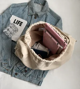 Innenansicht der cremefarbenen Hobo-Bag mit Kordelzug und großzügigem Stauraum mit Taschen