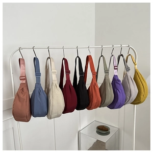 Detailed display of crescent dumpling bags in ten vibrant colors on a white minimalist rack