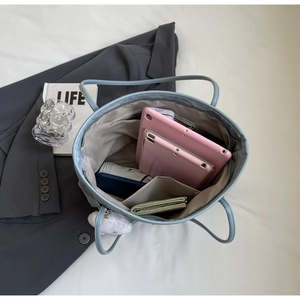 Top view of large light blue tote bag interior with multiple compartments and storage