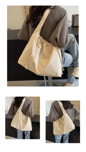 Vista dettagliata della borsa tote grande in tela crema con coulisse e tracolla ampia