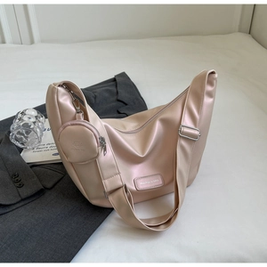 Close-up of champagne pink crescent shoulder bag with wide strap and round coin purse