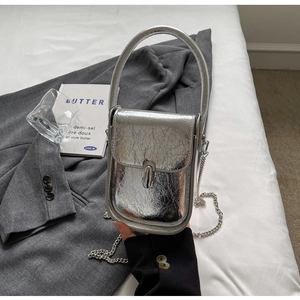 Detailed close-up of a silver cracked texture mini crossbody bag with metal chain strap