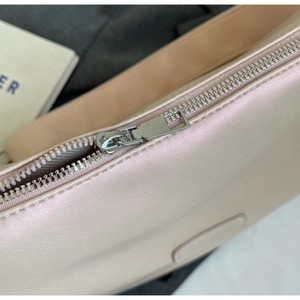 Detail of pearlescent pink texture with silver metal zipper and precise stitching