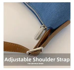Detail of blue denim shoulder bag showing silver zipper and adjustable leather strap