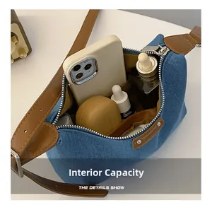 Internal capacity of denim shoulder bag showing space for phone and cosmetics
