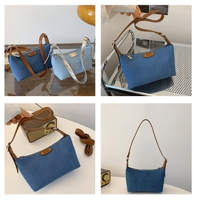 Detail view of denim underarm bags in vintage blue and light blue with leather straps