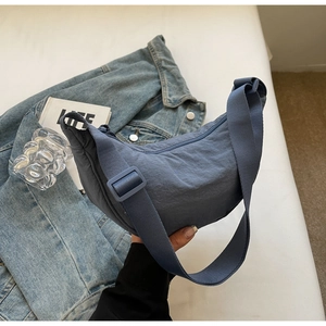 Detailed view of dust-blue waterproof nylon dumpling bag with adjustable strap