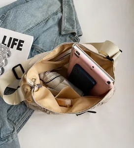 Detail view of the spacious inner compartment of the beige pleated crossbody bag for daily storage