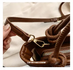 Detail of premium golden metal hook and brown leather strap on denim bucket bag