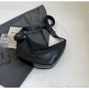 Detail of black leather half-moon crossbody bag with adjustable wide strap and coin purse