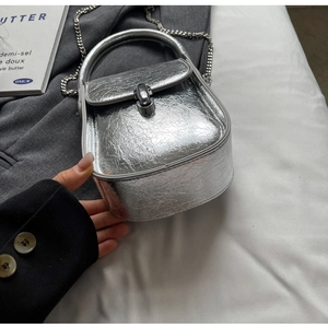 Silver metallic crossbody bag featuring pleated texture and a sleek metal chain strap