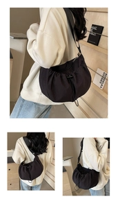 Détail d'un grand sac plissé noir avec fermeture à cordon et large bandoulière