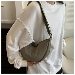 Detail of army green nylon hobo bag with smooth zipper closure and wide strap