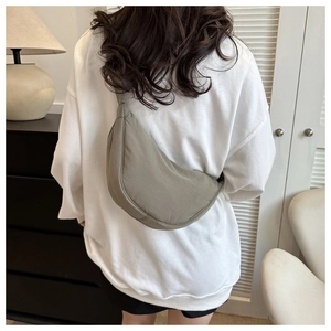Olive green waterproof nylon dumpling bag shown worn on back for casual styling