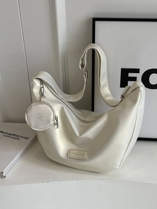 Minimalist white half-moon shoulder bag with a round coin purse and adjustable strap